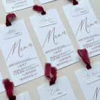 Set of menu cards with names and red ribbons on a light background